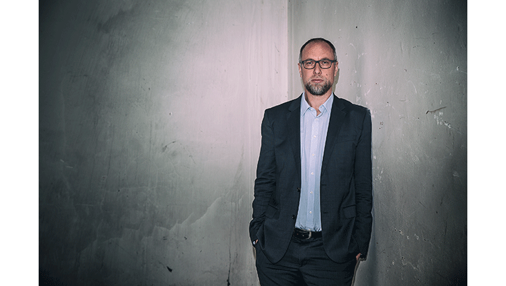 landscape portrait of Prof. Coeckelbergh standing in front of plain wall