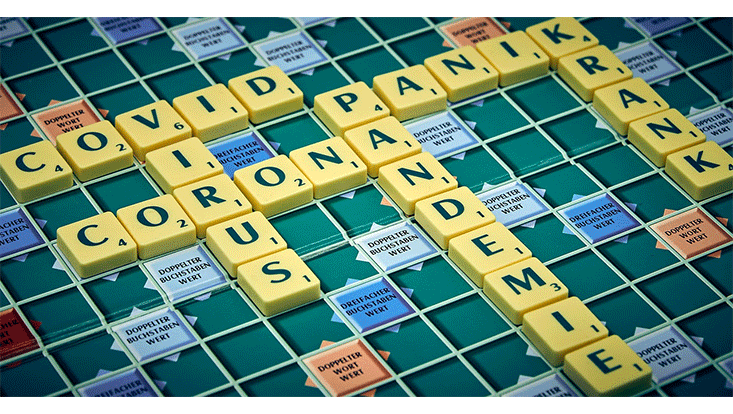 Scrabble-Spielbrett, auf dem Worte zur Corona-Pandemie gelegt sind
