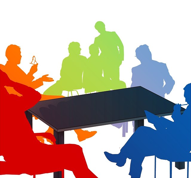 Bunte Silhouetten von um einen Tisch herumsitzenden Menschen. Einige notieren etwas, andere Reden, wieder andere fassen sich an die Stirn