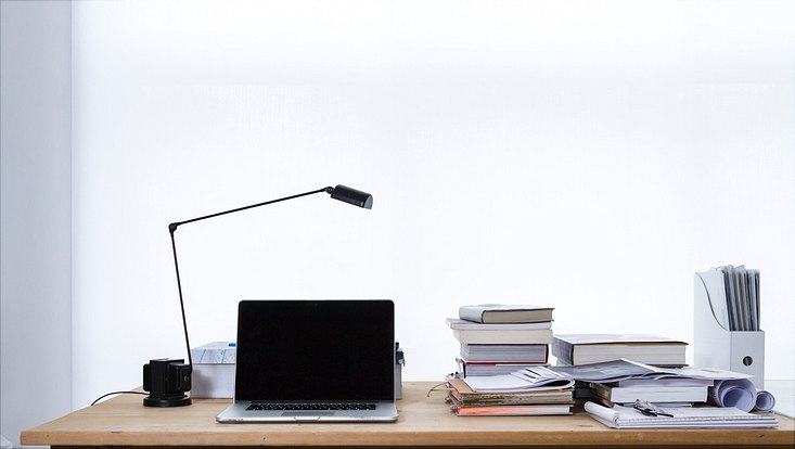 Schreibtisch mit Laptop und Büchern