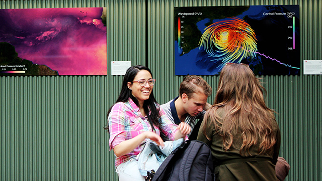Frauen stehen vor einer grünen Wand und unterhalten sich.