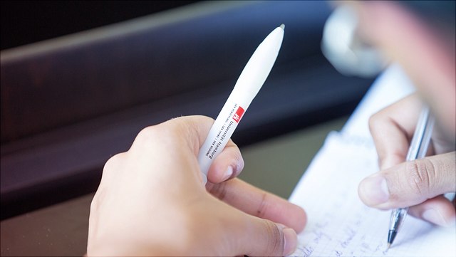 Schreibende rechte Hand mit UHH-Werbestift