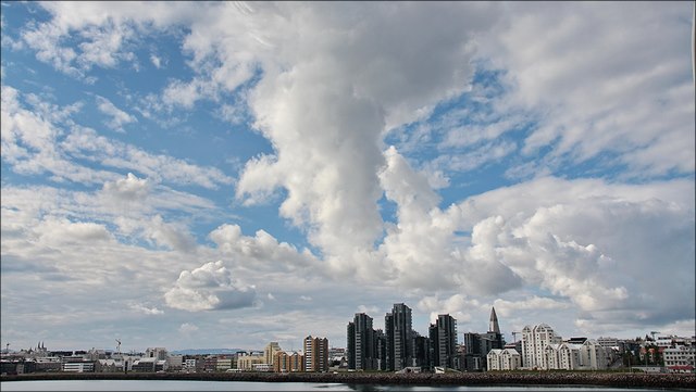 A blanket of white clouds hovers over a city