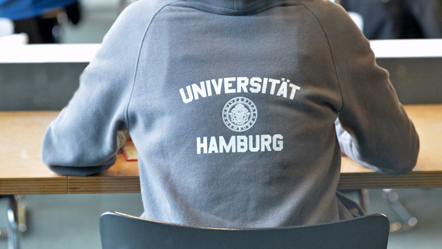 Mit dem Rücken zugewandt sitzender Studierender in der Bibliothek