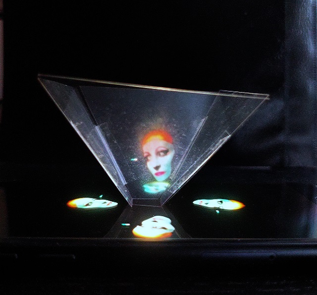 Bei der Hologrammillusion sieht es durch die durchsichtige Pyramide aus Folie so aus, als würde das Bild über dem Handy schweben.
