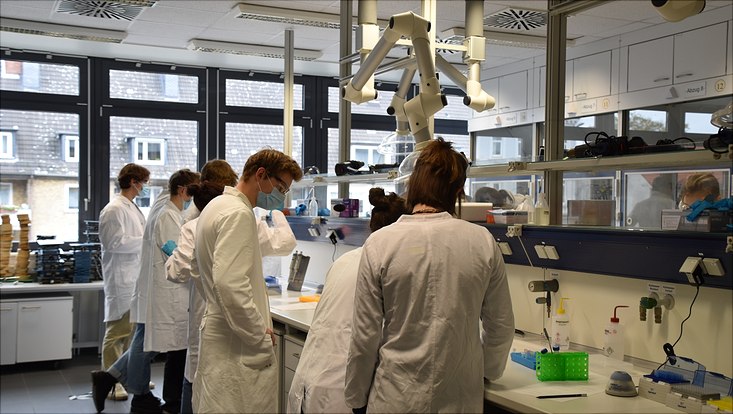 lab-733x414 several people in white coats in a chemistry lab
