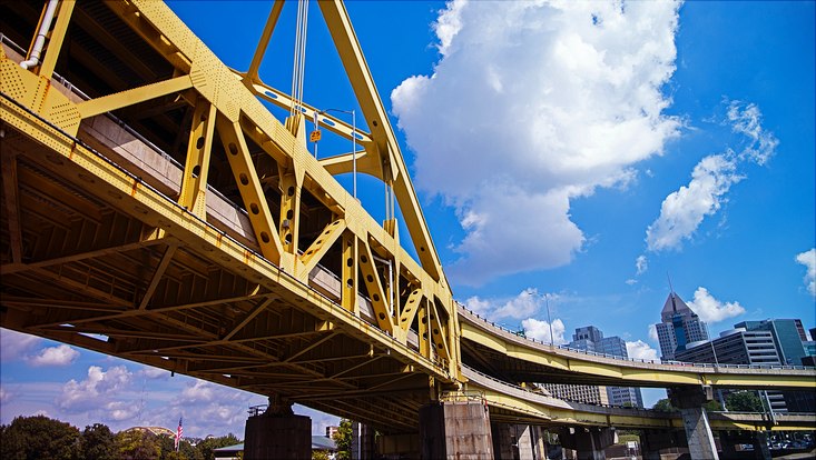yellow steel bridge in front of skyscrapers in Pittsburgh, PA, USA