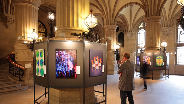 Exhibition of colourful pictures. A man observes a picture.