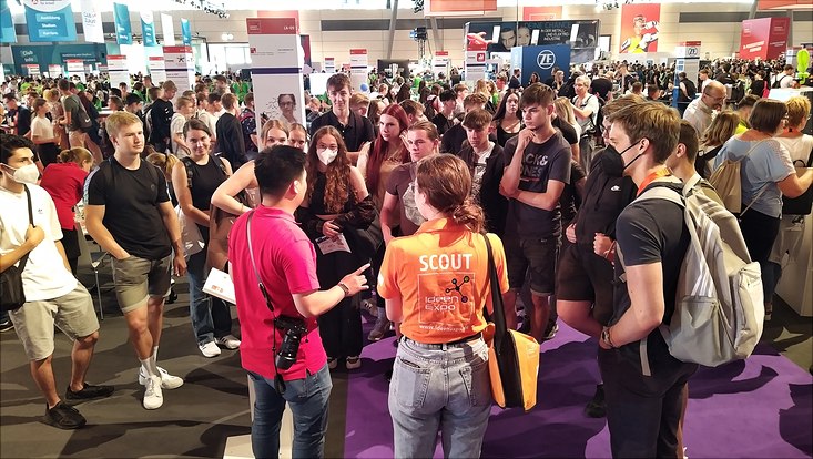 Many young peolpe in a big hall