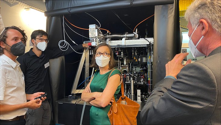 Drei Männer und eine Frau vor einem Experiment.