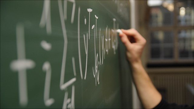 Student writing on a chalk board