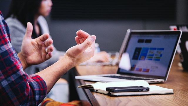 hands with notebook and computer in the backround