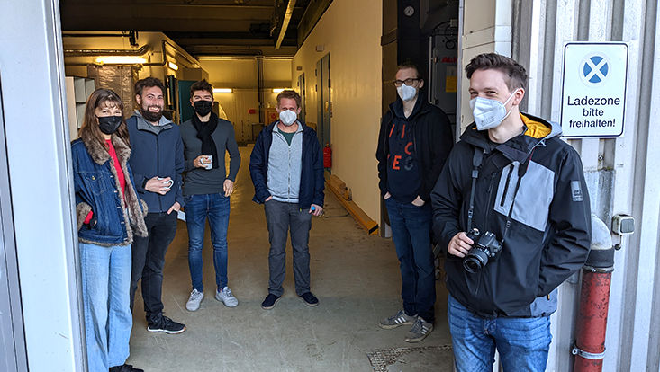 anlieferung-vakuumkammer-5-c-grefe Prof. Dr. Oliver Gerberding (dritter v. rechts) und sein Team verfolgen die Anlieferung der Vakuumkammer. Künftig können sie die entwickelten Komponenten für Gravitationswellendetektoren unter realistischen Bedingungen in der Vakuumkammer testen.