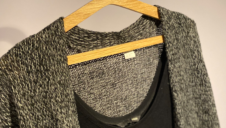 black shirt and grey vest on hanger