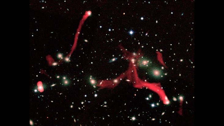 The filamentary structures observed by LOFAR at the center of Abell 2255, here reported in red. These radio emissions are due to trails of particles and magnetic fields released by the galaxies during their motion inside the cluster