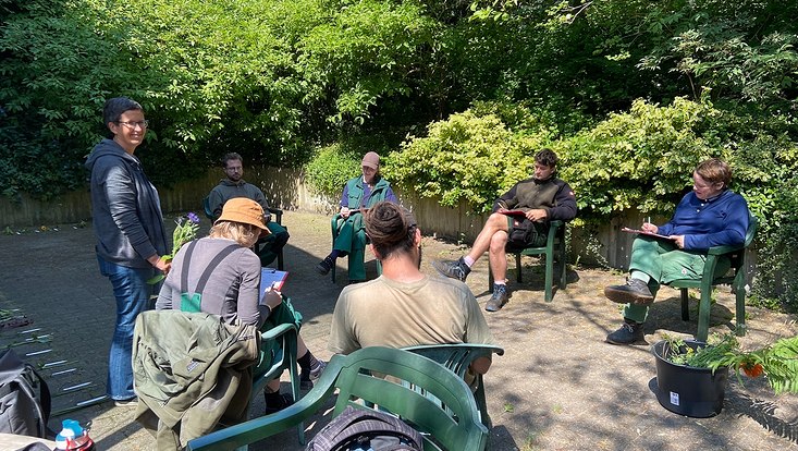 ausbildung grünes klassenzimmer 733x414 Gruppe junger Menschen sitzt im Kreis auf einer Terrasse zum Unterricht im Botanischen Garten