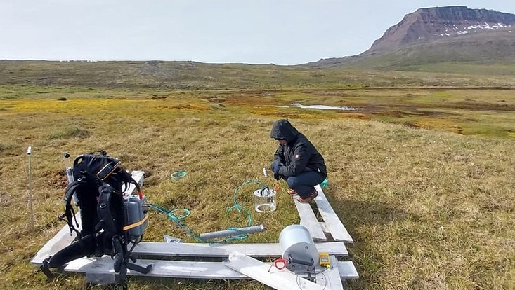 scientist measuring soil gas fluxes with opaque chamber