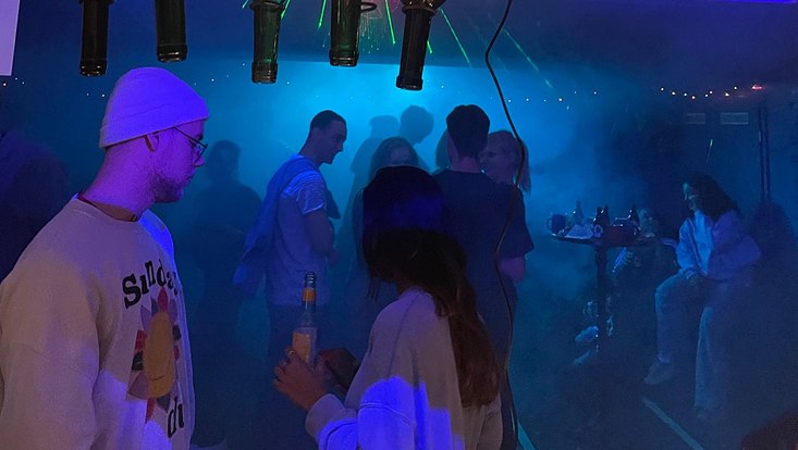 Menschenmenge in einem dunkle nebeligen Raum