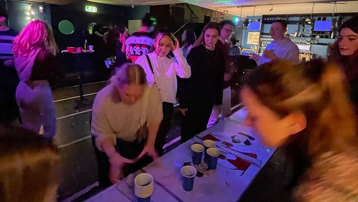 Studierende am Bierpong spielen