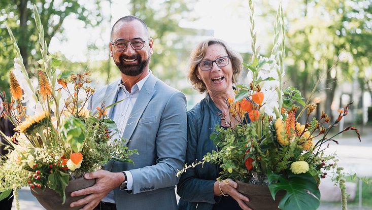 dynament-2023-3331-733x414 A man and a woman hold flowers