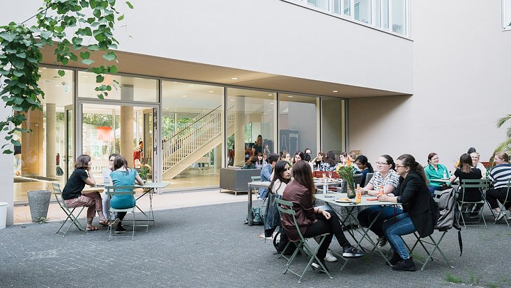 dynament-2023-3504-733x414 women sit together in a courtyard