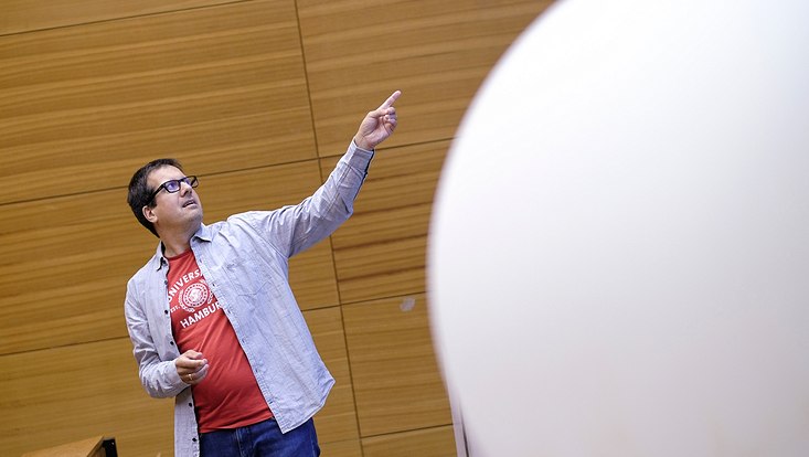 -dsf0798-733x414 Professor im Hörsaal neben Wetterballon.