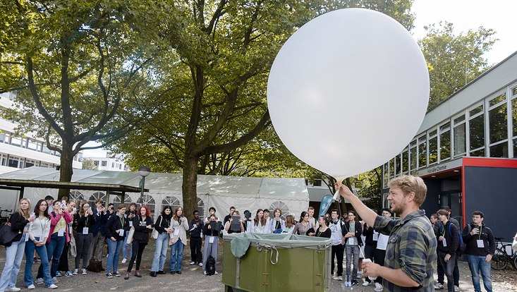 -dsf0713-733x414 Professor und Schülerinnen auf dem Campus. Ein Experiment mit einem Wetterballon wird durchgeführt und erklärt.