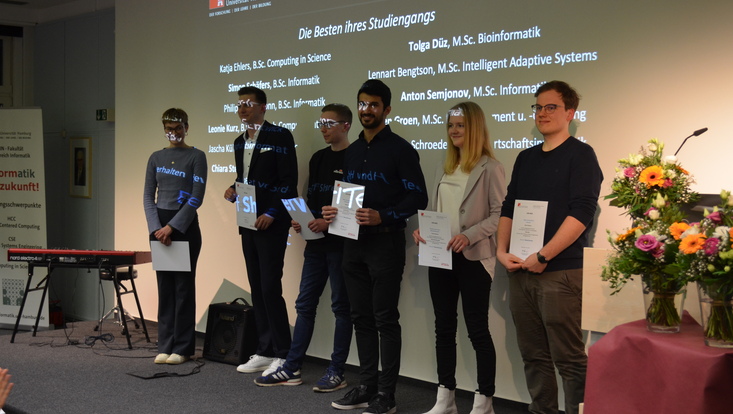 Die Besten ihres Studiengangs stehen zusammen auf der Bühne