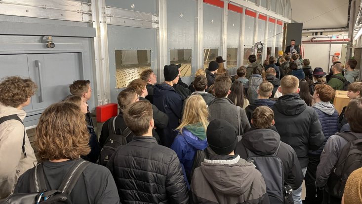 Eine Besuchergruppe vor dem Windkanal „WOTAN“