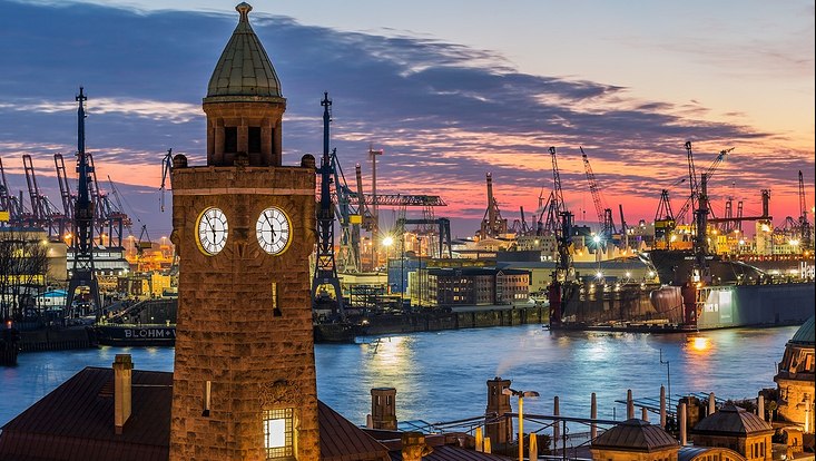 Hamburger Hafen mit Kränen bei Sonnenuntergangslicht