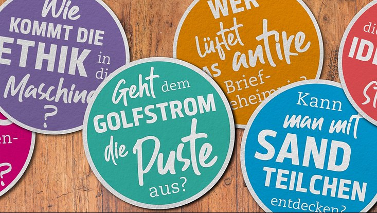 Ansammlung von Bierdeckeln mit Forschungsfragen