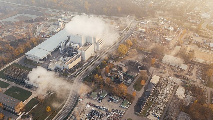 Landschaft mit Fabrik und Emissionsrauch