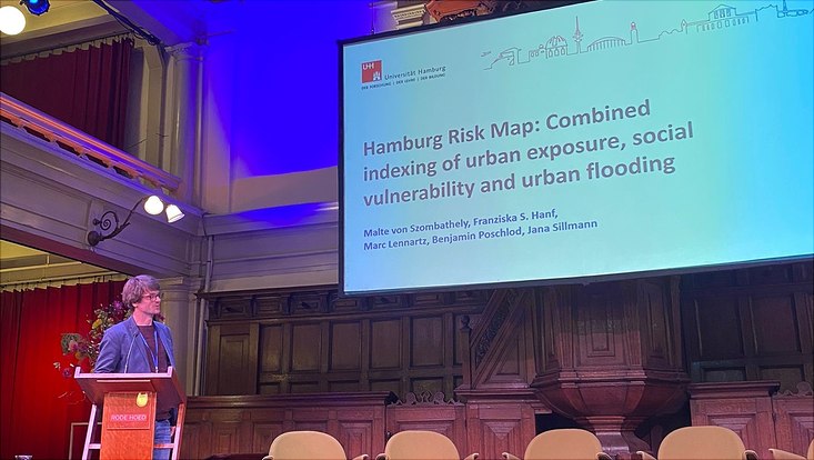 natural-hazards-conference-3-733x414 Postdoctoral researcher Malte von Szombathely presenting ongoing research for a Hamburg Risk Map, focusing on pluvial flooding.