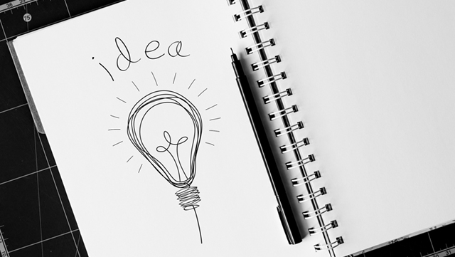 Notebook with lightbulb and pen
