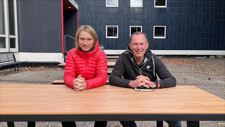 Prof. Carmen Herrmann und Prof. Fischer sitzen an einem Tisch auf dem Vorplatz des Fachbereichs