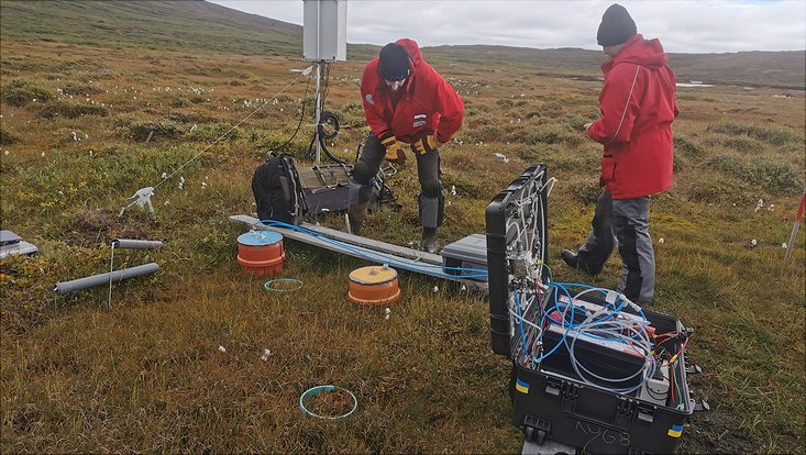 Two scientists preparing automatic CH4 oxidation throughflow system in a tundra valley