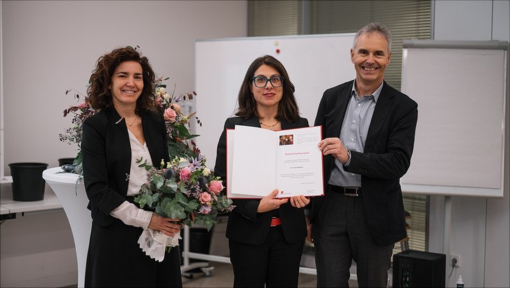 Two awardees with flowers in their hands.
