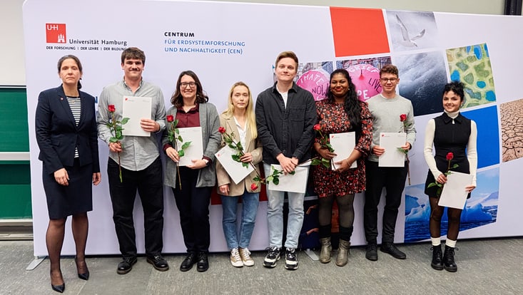 2025-02-cen-graduiertenfeier--7292-733x414 Prof. Johanna Baehr mit sieben Master-Absolvent:innen, die jeweils ihre Urkunde und eine Rose in den Händen halten.
