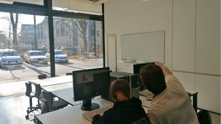 Design ohne Titel(1) Zwei Studierende sitzen an der Analysen von Daten aufgenommen vom CMS Experiment.