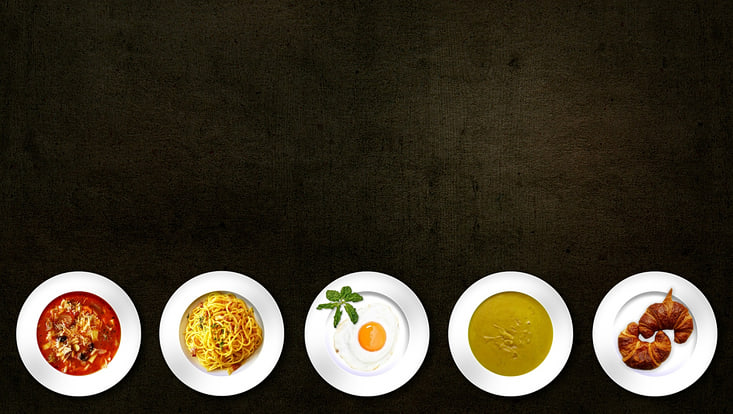 Different foods are plated in front of a dark background.