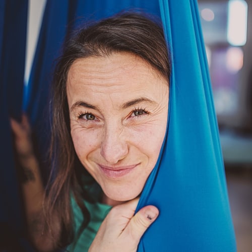 The eyes of a woman with a blue scarf looking into the camera