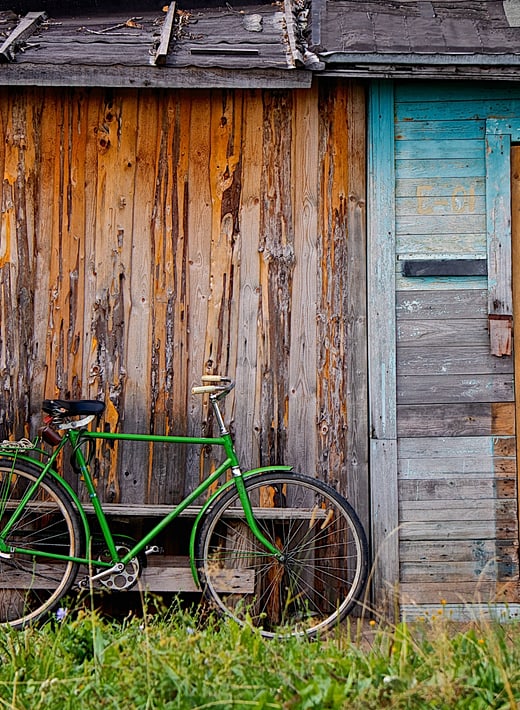 green man's bicycle leaning against old wooden shed