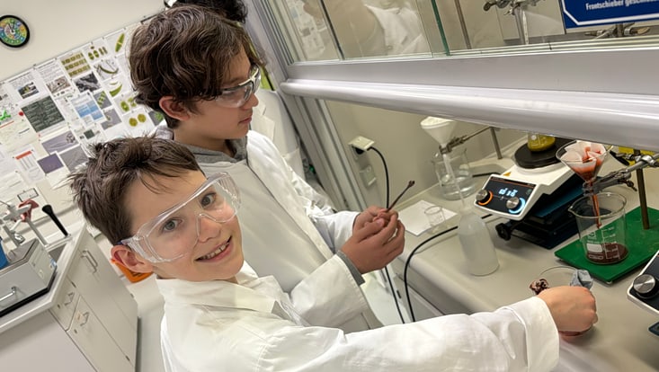 bild-20250312-110540-7f90b710-733x414 Zwei Jungen stehen im Labor vor dem Abzug und experimentieren