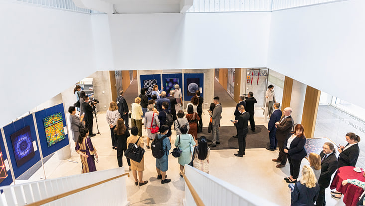 Blick von oben auf die Besuchsgruppe vor den Bildern der Arts & Science-Ausstellung.