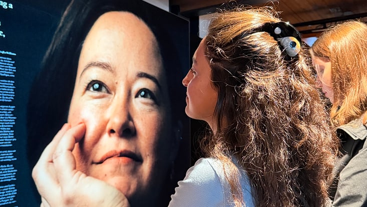 Zwei junge Frauen blicken in der Ausstellung auf ein großes Porträtfoto einer Meeresforscherin