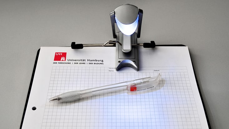 A ballpoint pen lies on a notepad