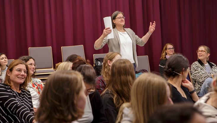 Eine Frau erhebt sich im Publikum
