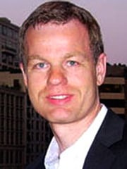 Profilbild von Andreas Lange: Eine männlich gelesene Person mittleren Alters. Andreas hat kurze hellbraune, glatte Haare und trägt einen dunklen Anzug mit weißem Hemd. Er lächelt.