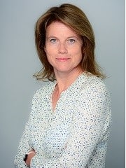 Das Bild ist ein Profilbild von Simone Rödder, einer weiblich gelesenen Person mit dunkelblonden, glatten, schulterlangen Haaren. Sie trägt eine weiße Blause mit einem blauen Blumenmuster. Sie lächelt.