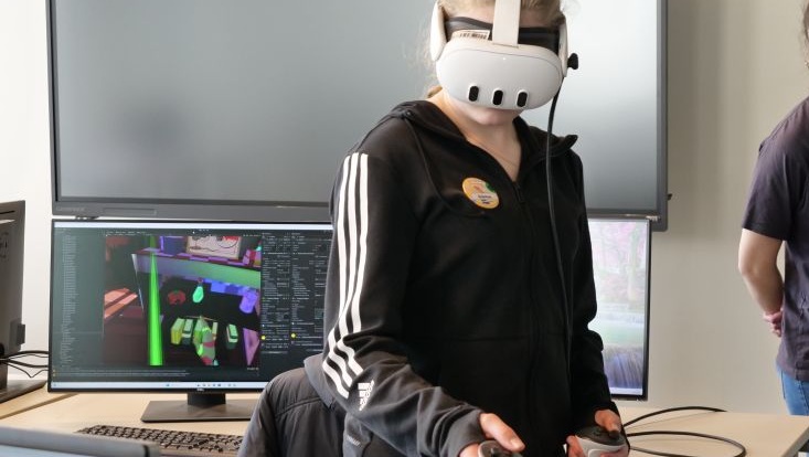 A girl wearing VR glasses, interacting in a virtual world.